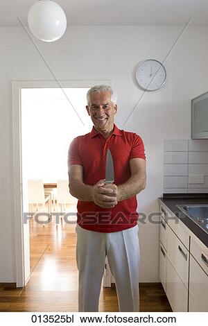 smiling mature man holding knife in kitchen View Large Photo Image Stock Image - smiling mature man holding knife in kitchen. Fotosearch