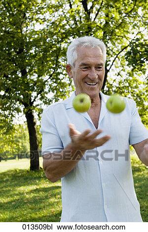 smiling mature man juggling with fruit View Large Photo Image Stock Image - smiling mature man juggling with fruit. Fotosearch