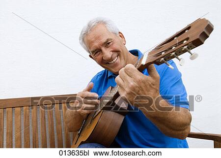Stock Image - smiling mature man with guitar. Fotosearch
