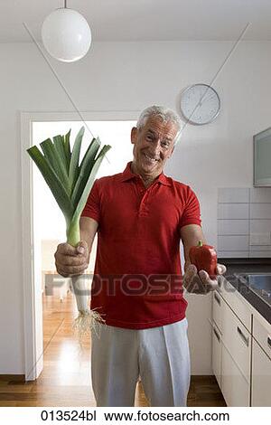 smiling mature man with red pepper and leek in kitchen View Large Photo Image Stock Image - smiling mature man with red pepper and leek in kitchen. Fotosearch
