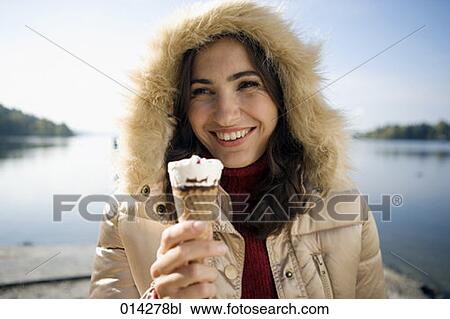 smiling woman in winter clothes holding ice cream View Large Photo Image Stock Image - smiling woman in winter clothes holding ice cream. Fotosearch