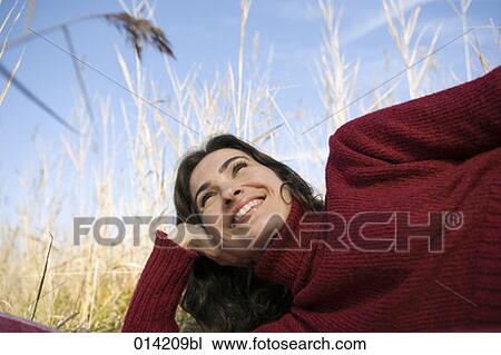 smiling woman lying in field of reeds View Large Photo Image Stock Image - smiling woman lying in field of reeds. Fotosearch