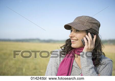smiling woman talking on cellular phone outdoors View Large Photo Image Stock Image - smiling woman talking on cellular phone outdoors. Fotosearch