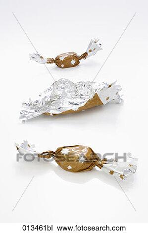 Stock Image - still life of three sweets one unwrapped. Fotosearch