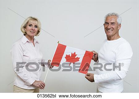 two mature people showing flag of Canada View Large Photo Image Stock Image - two mature people showing flag of Canada. Fotosearch