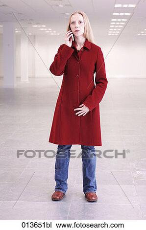 woman in red coat talking on mobile in empty office space View Large Photo Image Stock Image - woman in red coat talking on mobile in empty office space. Fotosearch