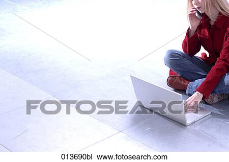 young businesswoman sitting on floor working with notebook and talking on mobile View Large Photo Image Stock Image - young businesswoman sitting on floor working with notebook and talking on mobile. Fotosearch