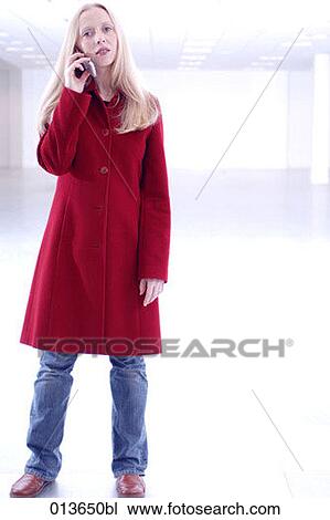 young businesswoman standing in empty office talking on mobile phone View Large Photo Image Stock Image - young businesswoman standing in empty office talking on mobile phone. Fotosearch