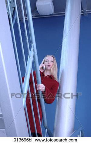 young businesswoman standing in staircase listening to her mobile View Large Photo Image Stock Image - young businesswoman standing in staircase listening to her mobile. Fotosearch