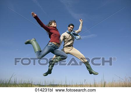 young couple in rubber boots jumping in the air View Large Photo Image Stock Image - young couple in rubber boots jumping in the air. Fotosearch