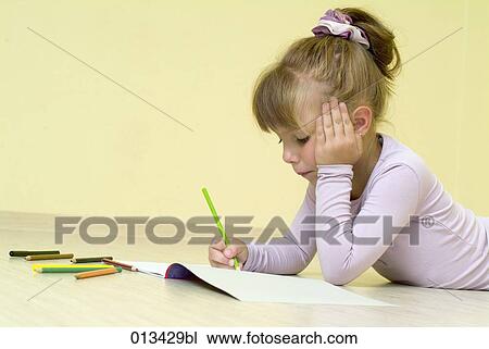 Stock Image - young girl playing with her painting book. Fotosearch