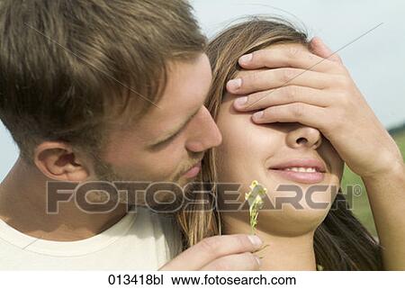 Stock Image - young man plaing peekaboo with girlfriend. Fotosearch