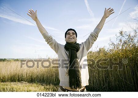 young man raising his arms in autumnal field View Large Photo Image Stock Image - young man raising his arms in autumnal field. Fotosearch