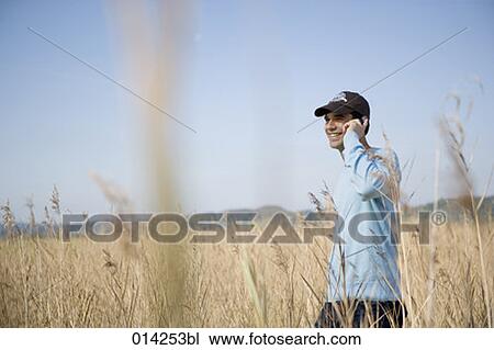 young man with cap taling on phone in field of reeds View Large Photo Image Stock Image - young man with cap taling on phone in field of reeds. Fotosearch