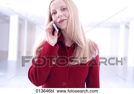young woman giving a friendly look while talking on cellphone View Large Photo Image Stock Image - young woman giving a friendly look while talking on cellphone. Fotosearch