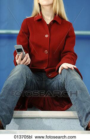 young woman sitting on stairs holding cellphone View Large Photo Image Stock Image - young woman sitting on stairs holding cellphone. Fotosearch