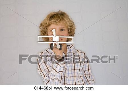 blonde boy holding toy plane and looking at camera View Large Photo Image Stock Image - blonde boy holding toy plane and looking at camera. Fotosearch