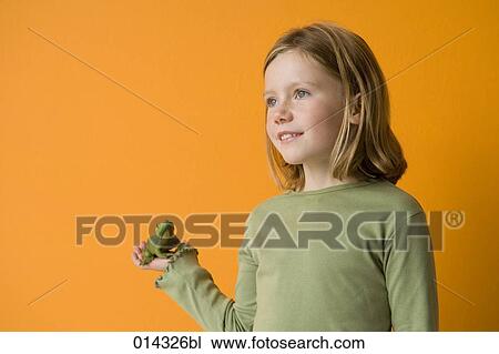 Stock Image - blonde girl holding frog. Fotosearch