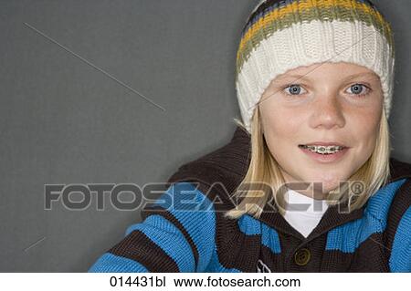 Stock Image - boy with braces in winter clothing looking at camera . Fotosearch