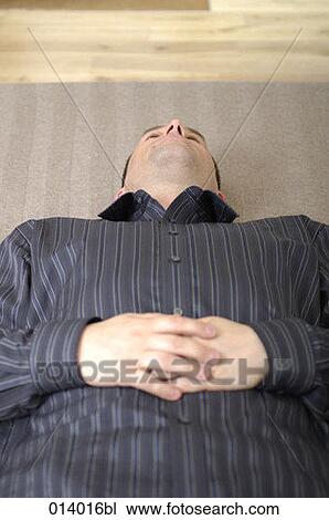 Stock Image - businessman taking a nap on the floor. Fotosearch
