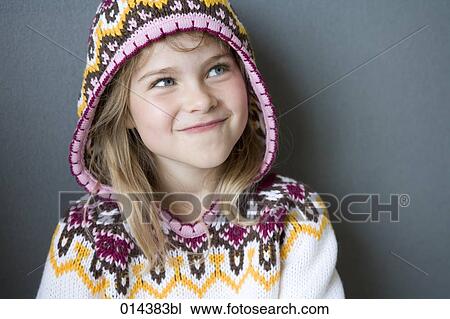 Stock Image - cheeky girl in winter pullover with hood. Fotosearch