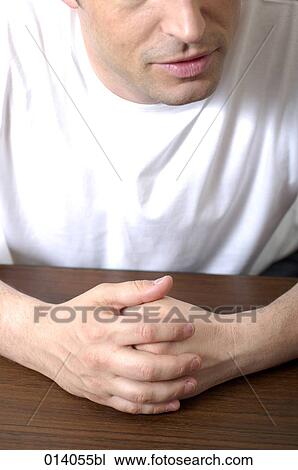 close-up of man sitting at table with folded hands talking View Large Photo Image Stock Image - close-up of man sitting at table with folded hands talking. Fotosearch