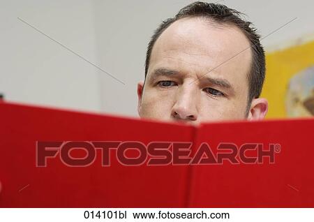 close-up of young man reading red book View Large Photo Image Stock Image - close-up of young man reading red book. Fotosearch