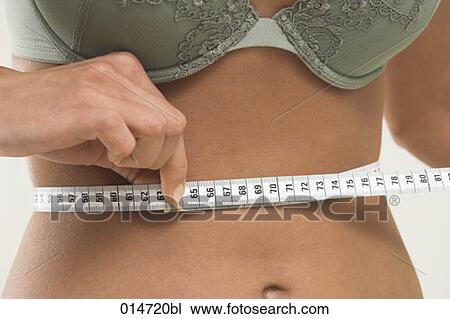 close-up of young women controlling her waistline with tape measure View Large Photo Image Stock Image - close-up of young women controlling her waistline with tape measure. Fotosearch