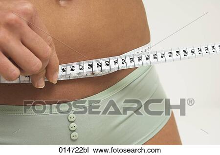 close-up of young women controlling her waistline with tape measure View Large Photo Image Stock Image - close-up of young women controlling her waistline with tape measure. Fotosearch