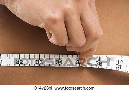 close-up of young women controlling her waistline with tape measure View Large Photo Image Stock Image - close-up of young women controlling her waistline with tape measure. Fotosearch