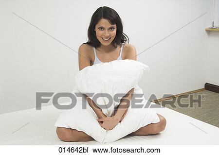 full body portrait of young woman sitting on bed and cuddling pillow View Large Photo Image Stock Image - full body portrait of young woman sitting on bed and cuddling pillow. Fotosearch