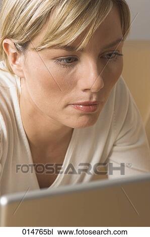 headshot of blonde woman working with laptop computer View Large Photo Image Stock Image - headshot of blonde woman working with laptop computer. Fotosearch