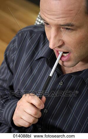 headshot of young businessman holding pen and thinking View Large Photo Image Stock Image - headshot of young businessman holding pen and thinking. Fotosearch