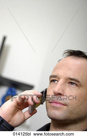 Stock Image - headshot of young businessman on mobile phone. Fotosearch