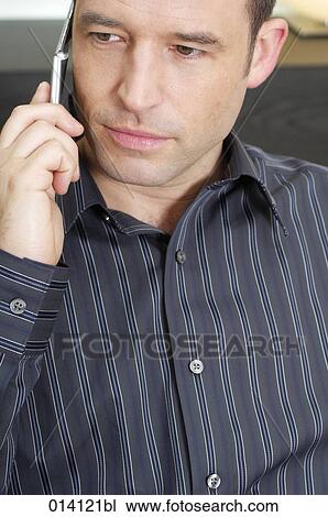 headshot of young man listening to mobile phone View Large Photo Image Stock Image - headshot of young man listening to mobile phone. Fotosearch