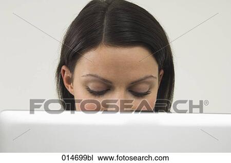 headshot of young woman behind laptop computer View Large Photo Image Stock Image - headshot of young woman behind laptop computer. Fotosearch
