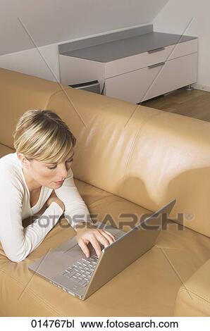 high angle view of blonde woman working with notebook computer in living room View Large Photo Image Stock Image - high angle view of blonde woman working with notebook computer in living room. Fotosearch