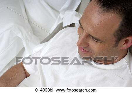 high angle view of man reaxing on bed View Large Photo Image Stock Image - high angle view of man reaxing on bed. Fotosearch