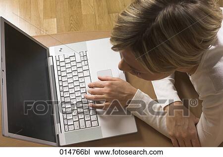 high angle view of young woman lying on the floor working with laptop computer View Large Photo Image Stock Image - high angle view of young woman lying on the floor working with laptop computer. Fotosearch