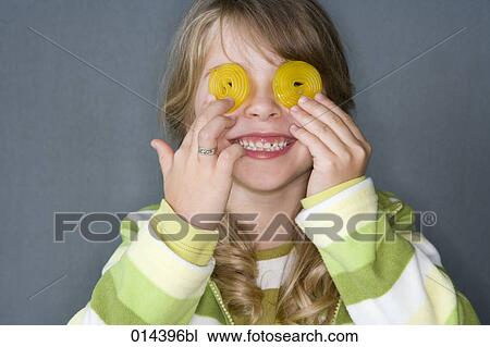 little girl covering her eyes with yellow sweets View Large Photo Image Stock Image - little girl covering her eyes with yellow sweets. Fotosearch