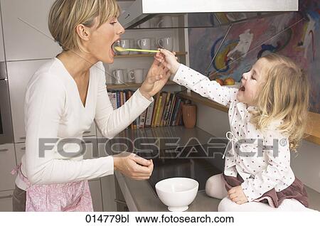 little girl feeding her mother in kitchen View Large Photo Image Stock Image - little girl feeding her mother in kitchen. Fotosearch
