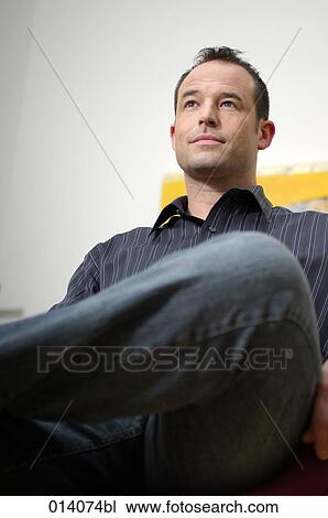 Stock Image - low angle portrait of confident young man. Fotosearch