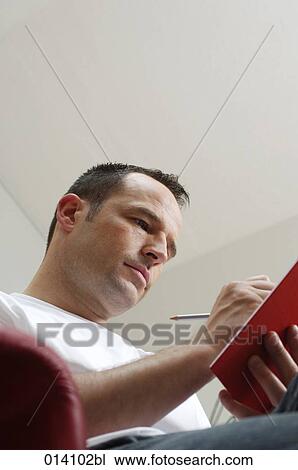 low angle portrait of young man writing in his diary View Large Photo Image Stock Image - low angle portrait of young man writing in his diary. Fotosearch