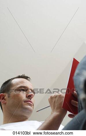 low angle portrait of young man writing in his diary View Large Photo Image Stock Image - low angle portrait of young man writing in his diary. Fotosearch