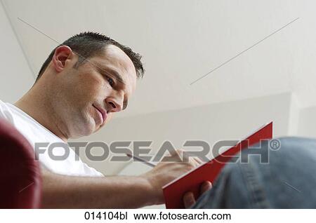 low angle portrait of young man writing in his diary View Large Photo Image Stock Image - low angle portrait of young man writing in his diary. Fotosearch