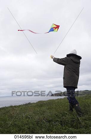 man letting kite fly on windy coast in autumn View Large Photo Image Stock Image - man letting kite fly on windy coast in autumn. Fotosearch