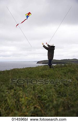 man letting kite fly on windy coast in autumn View Large Photo Image Stock Image - man letting kite fly on windy coast in autumn. Fotosearch
