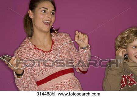 Stock Image - older sister sharing mp3 player with little brother. Fotosearch