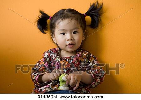 pigtailed baby with toy looking at camera View Large Photo Image Stock Image - pigtailed baby with toy looking at camera. Fotosearch