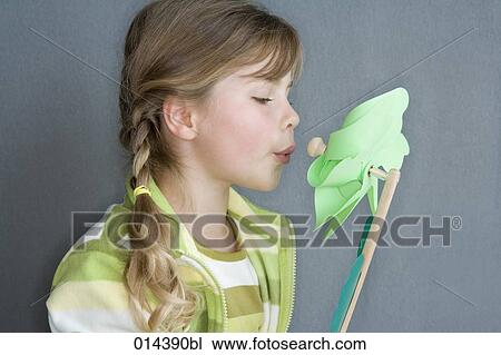 pigtailed girl blowing green windmill View Large Photo Image Stock Image - pigtailed girl blowing green windmill. Fotosearch
